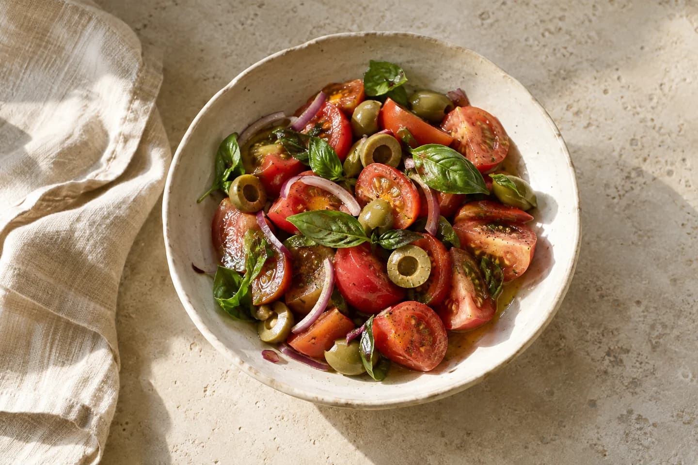 Insalata di pomodori, basilico e olive verdi snocciolate