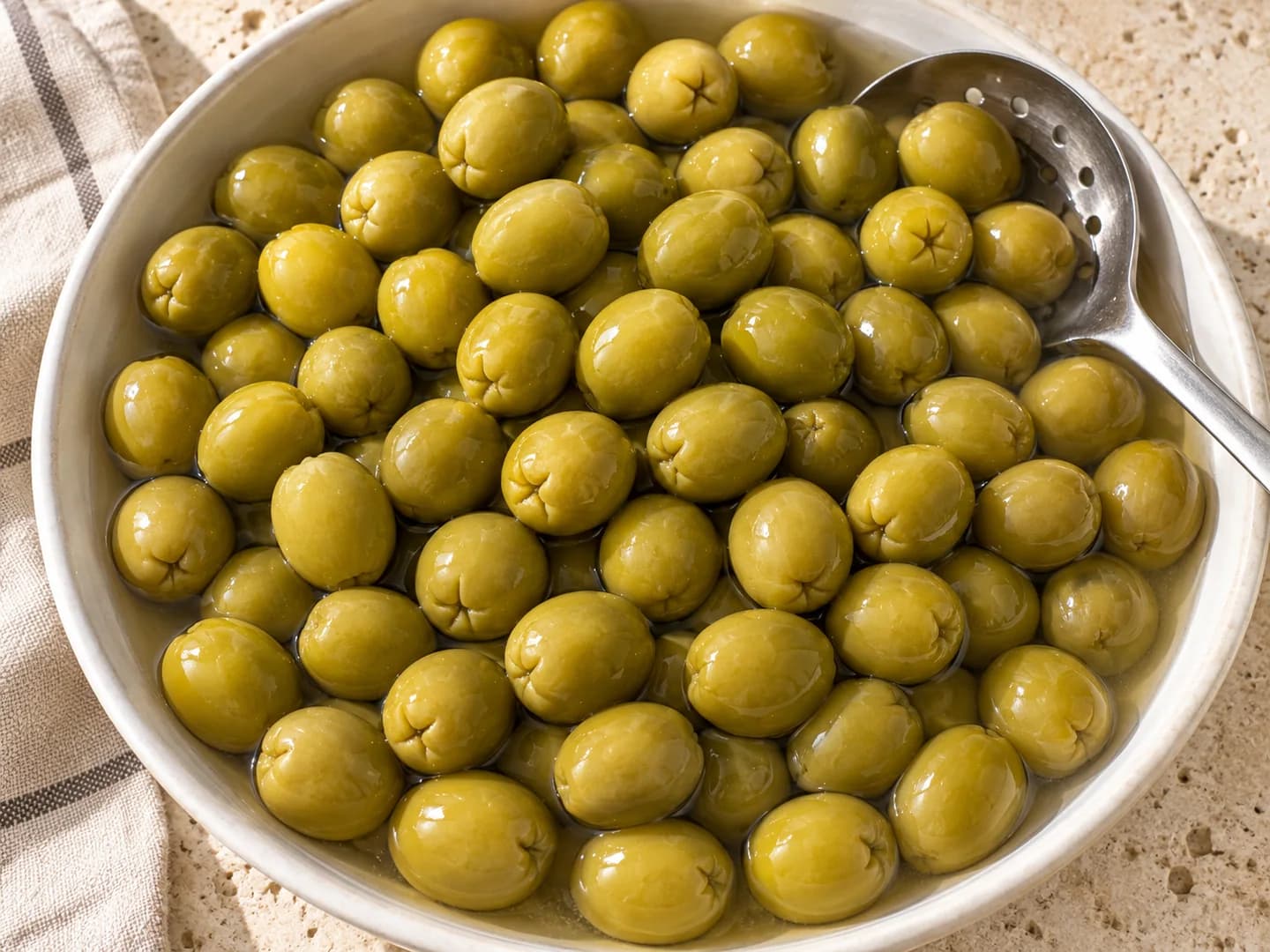 Olive verdi intere in salamoia in una ciotola di ceramica