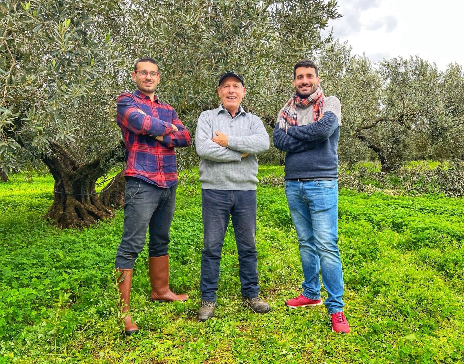 Padre e hijos frente a un olivo centenario de la finca