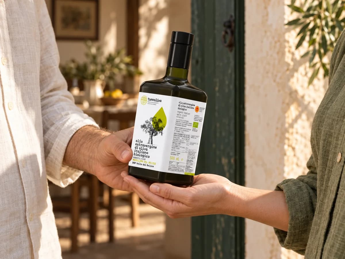Una bottiglia di olio passata di mano come regalo sulla soglia di casa